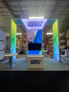 RENTAL: Modified RE-9045 Island Design with 16 Ft High Structure with Storage Closet with Locking Door, (2) 16 Ft High Double-Sided Lightboxes, (2) 16 Ft High Single-Sided Lightboxes, Ceiling Canopy Structure with White Scrim Fabric, (2) Large Monitor Mou